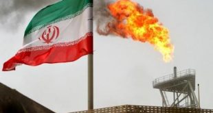 علم إيرانى إلى جانب شعلة غاز بحقل نفطى فى إيران. (رويترز).