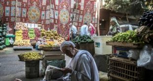 بائع فاكهة يقرأ صحيفة أمام محله في القاهرة، حيث تواصل الأسعار في مصر ارتفاعها الجنوني. (أرشيفية)
