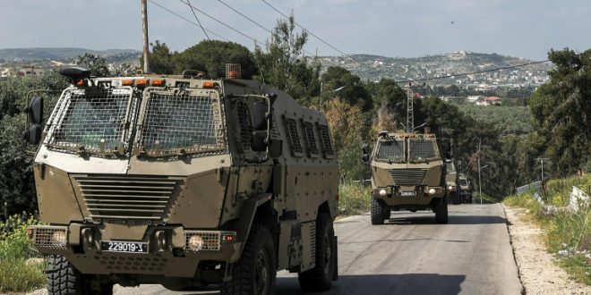 آليات عسكرية إسرائيلية تتحرك خلال تمر خلال مواجهات بين الجيش الإسرائيلي وفلسطينيين في مخيم جنين للاجئين الفلسطينيين شمال الضفة الغربية المحتلة ، 9أبريل 2022. (أ ف ب)