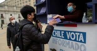 مواطن في تشيلي يتلقى نسخة من مشروع الدستور الجديد الذي جرى رفضه، وذلك في 31 أغسطس 2022 في سانتياغو. (أ ف ب)