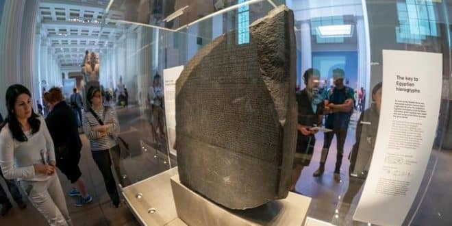 سائحون ينظرون إلى حجر رشيد بالمتحف البريطانى في لندن (الإنترنت)