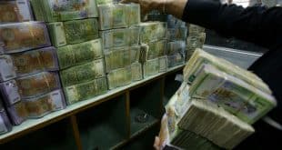موظف يحمل رزماً من العملة السورية داخل المصرف المركزي في دمشق، في 10 توفمبر 2022. (أ ف ب)