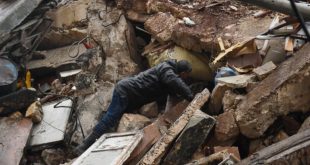 رجل يبحث عن ناجين بين أنقاض مبنى منهار في حلب في منطقة سيطرة النظام السوري بعد زلزال قوته 7,8 درجات ضرب تركيا وسوريا في السادس من فبراير 2023. (أ.ف.ب)
