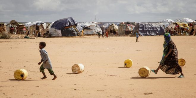 أطفال صوماليون يلفون حاويات مياه يعيدونها إلى مأواهم المؤقت في مخيم داداب للاجئين في كينيا في 23 مارس 2023. (أ ف ب)