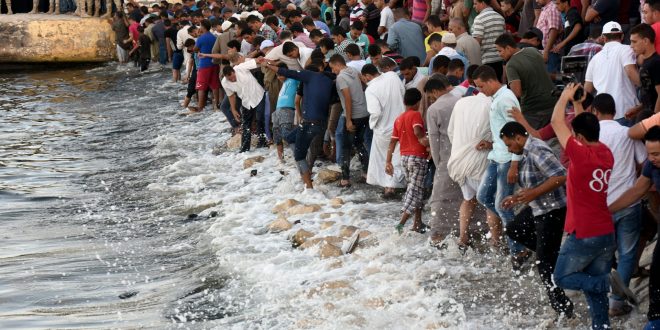 مواطنون يقفون على الشاطئ في مصر في انتظار انتشال الجثث، خلال عملية تفتيش بعد انقلاب قارب يقل مهاجرين غرقوا في البحر المتوس في سبتمبر 2017. (أرشيفية)