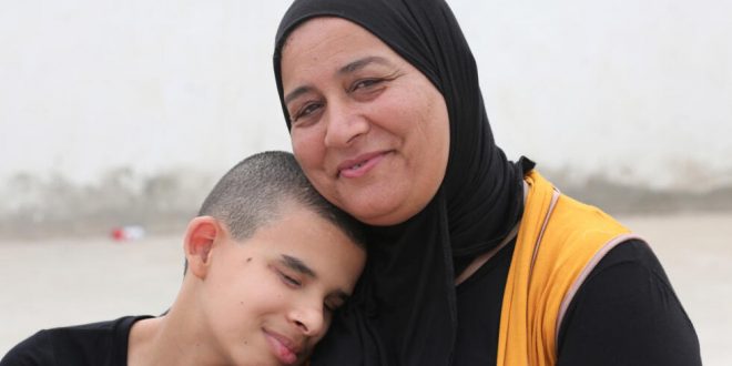 اياد وهو صبي ضرير يبلغ الثالثة عشرة مع والدته حكيمة يشارك في عرض راقص للتوعية إلى ذوي الاحتياجات الخاصة في تونس، في 20 سبتمبر 2023. (أ ف ب)