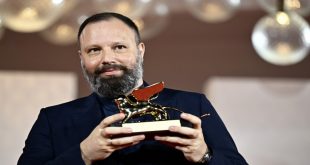 المخرج اليوناني يورغوس لانثيموس حاملاً جائزة "الأسد الذهبي" عن فيلمه "بور ثينغز" في ختام الدورة الثمانين لمهرجان البندقية السينمائي في التاسع من سبتمبر 2023. (أ ف ب)