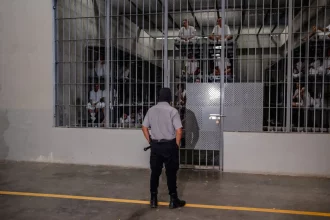 حارس سجن يراقب الزنازين التي يُحتجز فيها السجناء في مركز احتجاز الإرهابيين