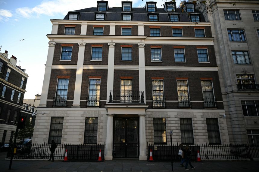 أشخاص يمرون أمام سفارة جمهورية الصين الشعبية في المملكة المتحدة، في ساحة بورتلاند بلندن